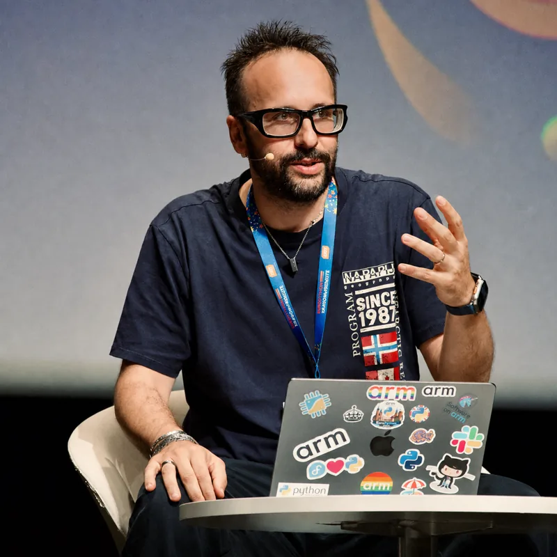 Diego Russo speaking on stage with a laptop