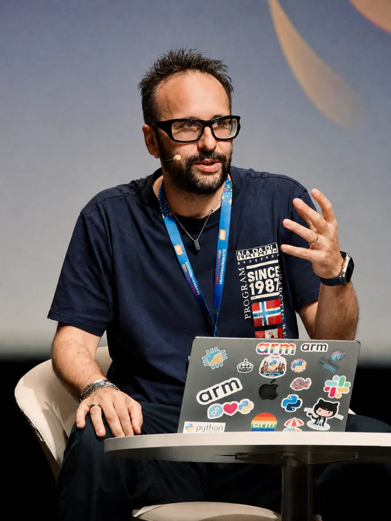 Portrait photo of Diego Russo speaking on stage with a laptop